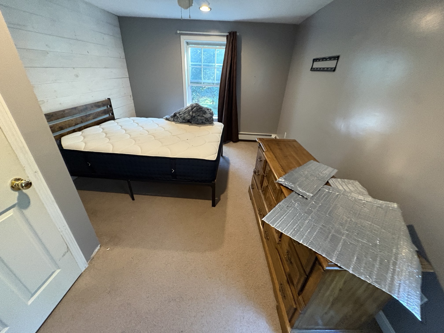 Bedroom with mattress, dresser and loose items before removal